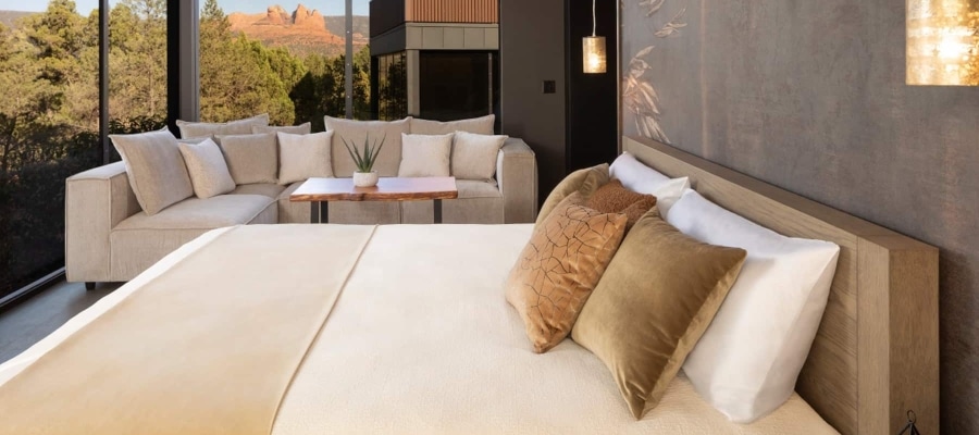 A luxurious hotel room with a large bed, sitting area, and a stunning mountain view.